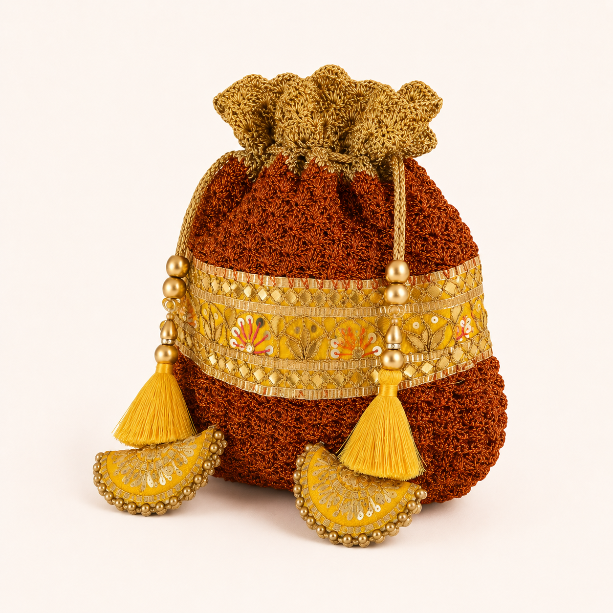 Handmade rust and gold crochet potli bag with zari embroidered border and silk tassels